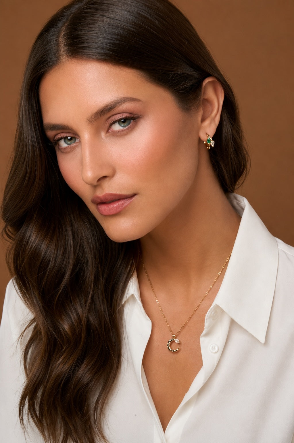 Model wearing 18k gold jewelry with pear shaped natural diamonds and Colombian emerald.