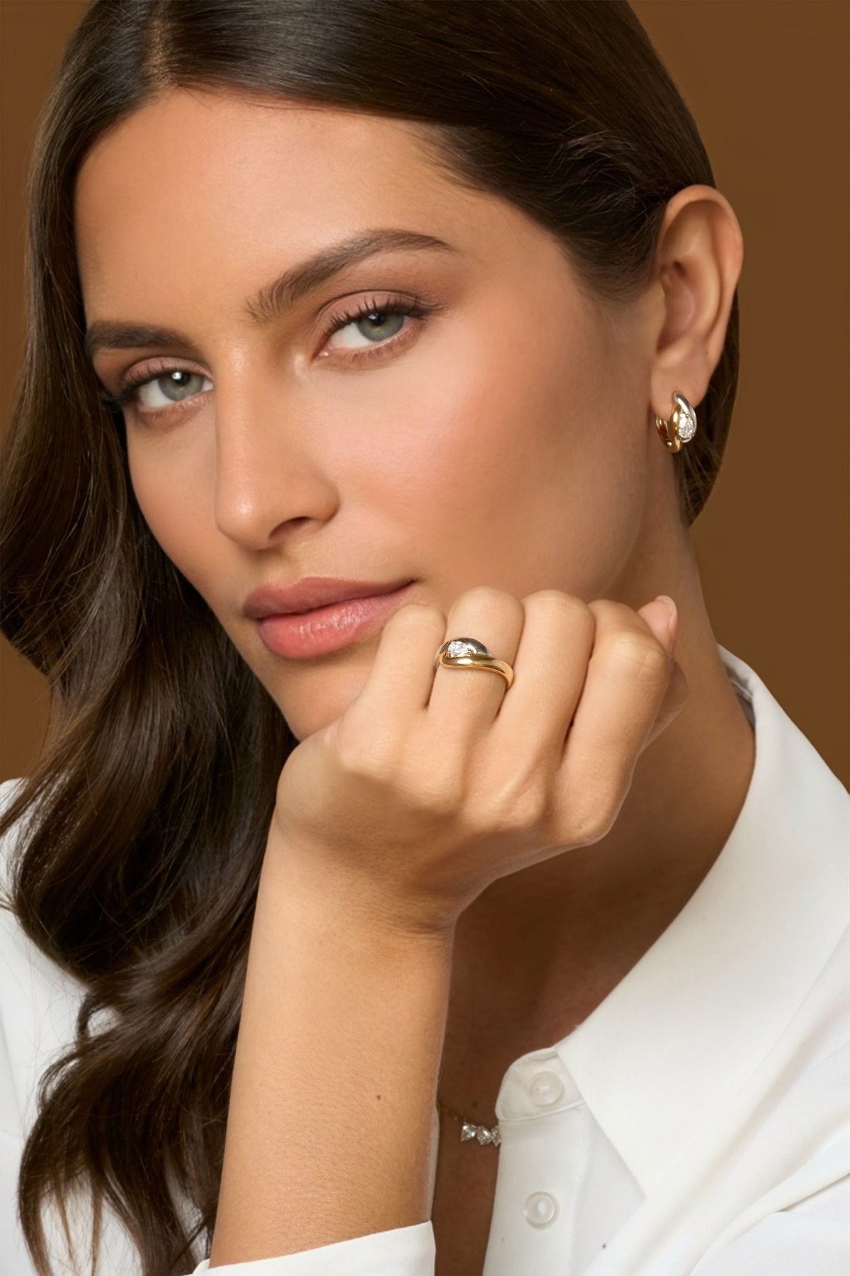 Model wearing matching 18k yellow gold and platinum jewelry with pear-shaped natural diamonds in a two tone cuddle setting.