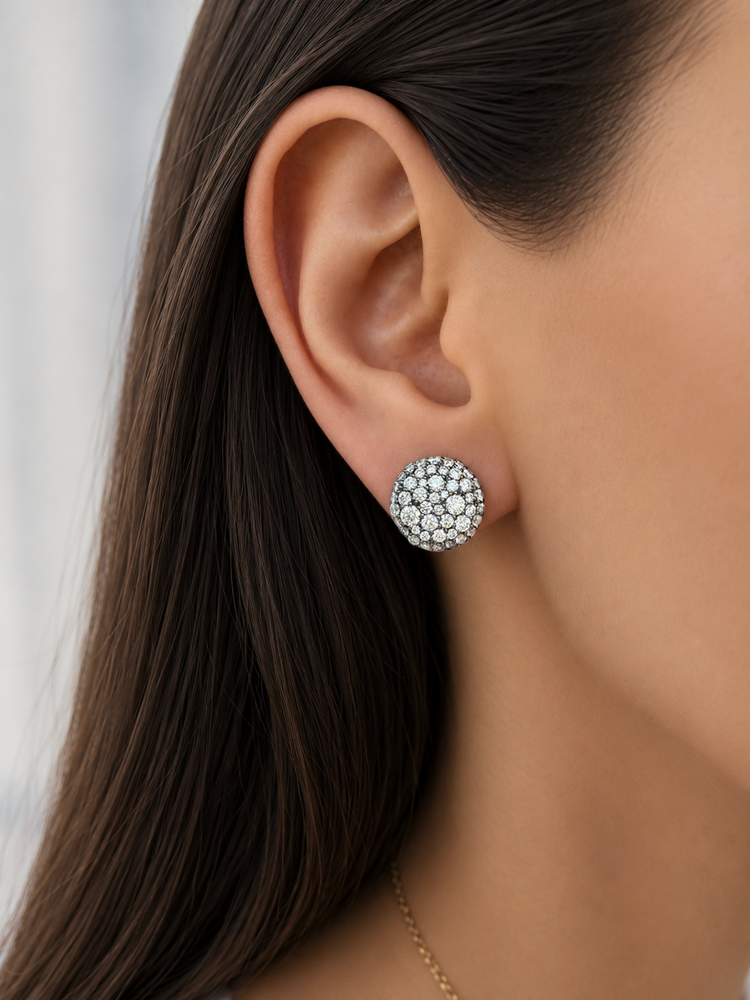Close-up of an ear wearing Prima 11mm Studs in yellow gold with round pave diamond centers set in black rhodium.