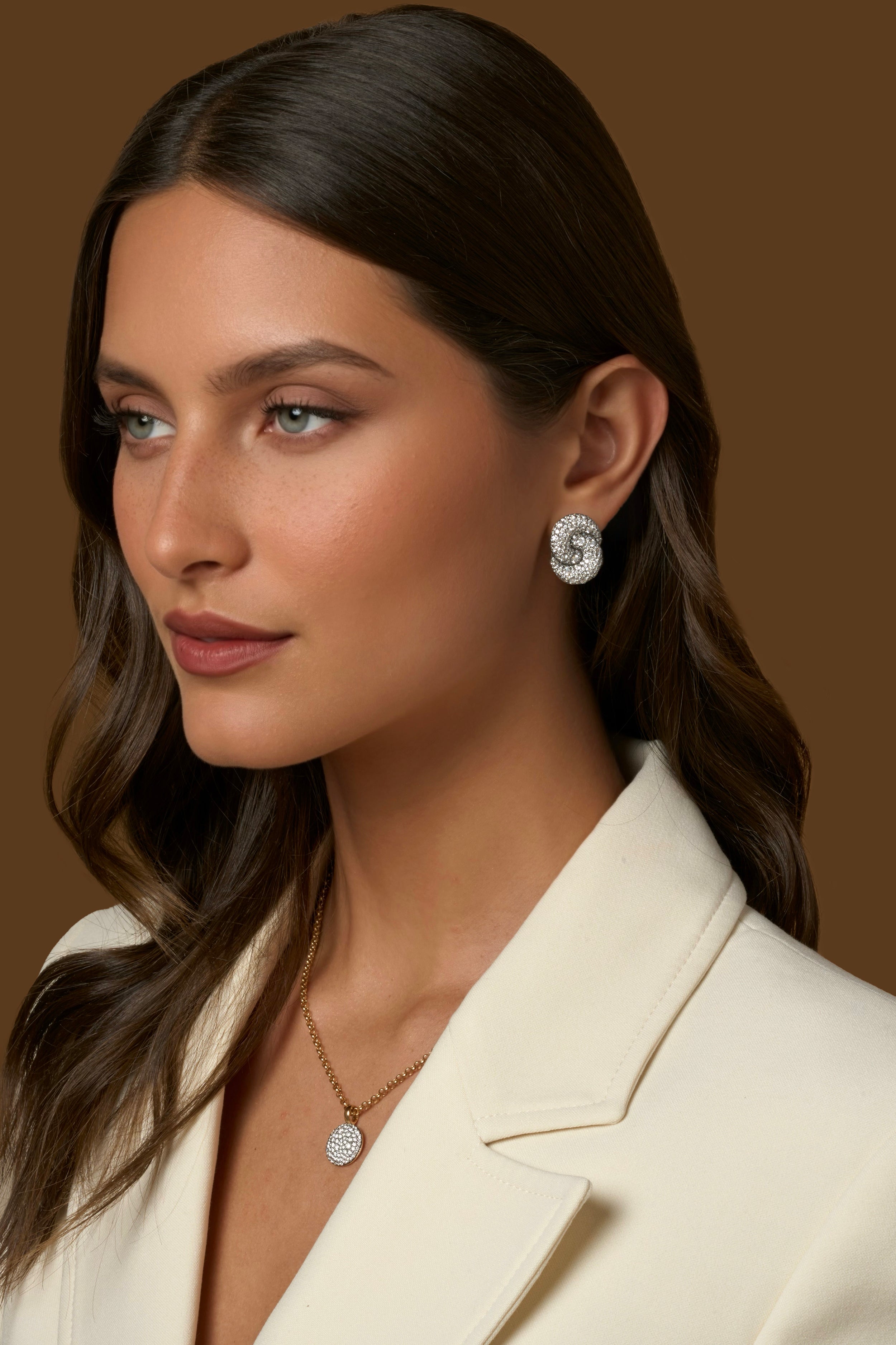 A close-up portrait of a woman wearing Large Duet Diamond Stud Earrings with all-over colorless pave diamonds in the signature Duet silhouette.