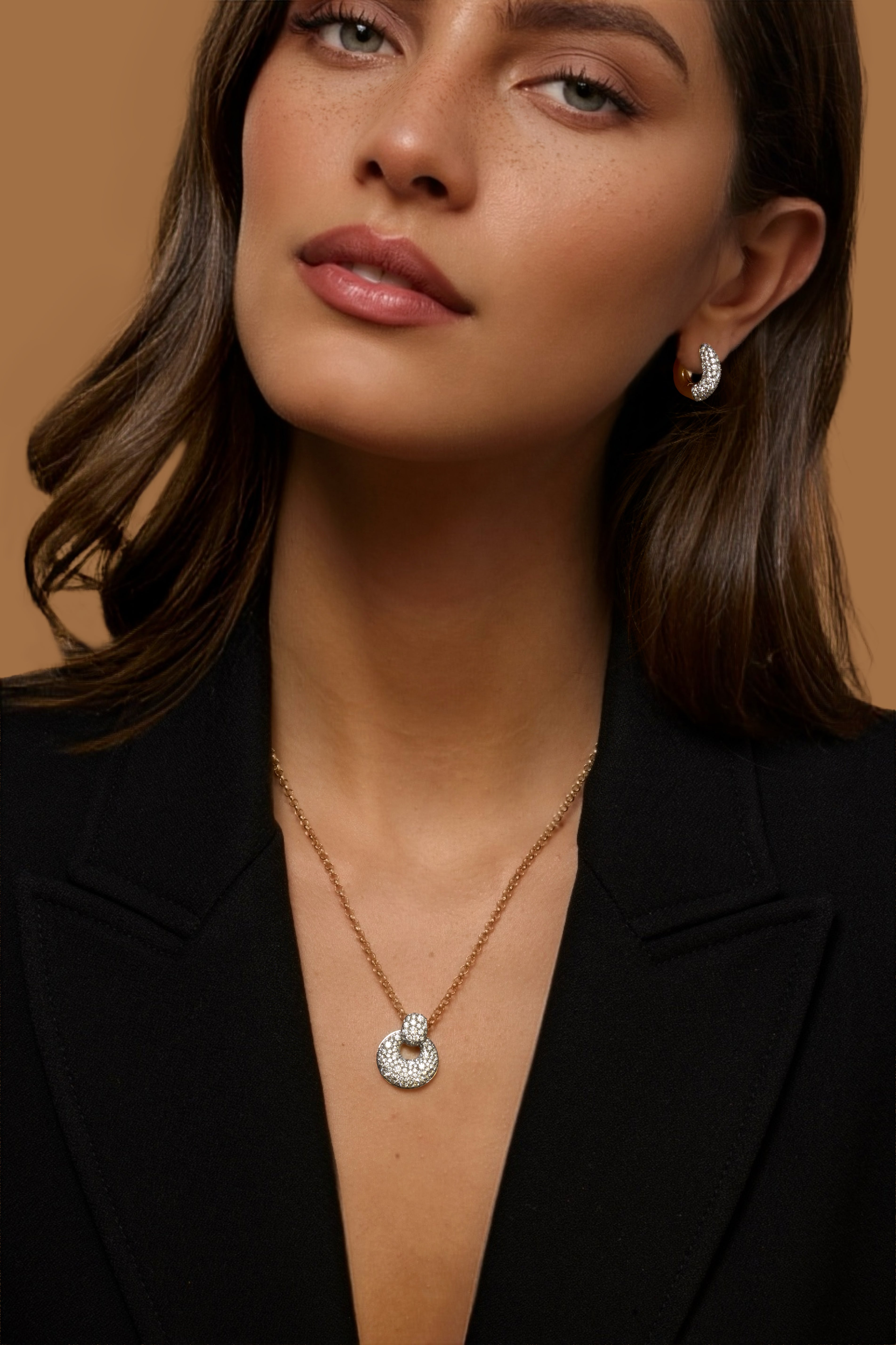 A close-up of a woman wearing releve jewelry featuring 18k yellow gold with diamond pave